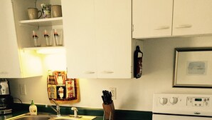 A kitchen with white cabinets, a double sink, a stove, and a microwave. - Apartment in the heart of Marquette w/ cable & wifi!!  Next to premier brewpub!! (Marquette)