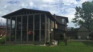 Une maison à deux étages avec une grande pièce au rez-de-chaussée, dotée de larges baies vitrées, et une pièce plus petite à l’étage supérieur.