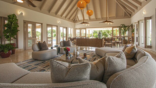 A spacious living area with a high ceiling, large windows, and a central seating area with sofas and a coffee table. - ATTRACTIVE RATES JUST REMODELED  - Near Beach 4 BD Amazing Golf View Villa (La Romana)