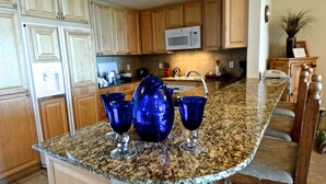 A kitchen with wooden cabinets, a granite countertop, and a microwave. - Sept Special: 7 nights just 1229 plus resort fees.  Great view & location (Pensacola Beach)
