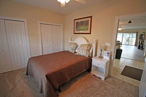 A bedroom with a bed, nightstand, and a framed picture on the wall.