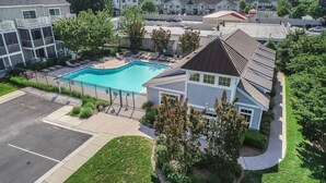 Ein Wohnhaus mit Schwimmbad, überdachter Terrasse und umzäunter Garten.