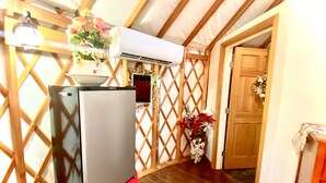 Una cocina compacta con refrigerador, un lavamanos pequeño y un muro de celosía de madera.