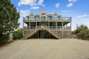 A multi-level wooden structure with a balcony, a staircase, and a door. - Free Pool Heat on All New 2026 Reservations (Corolla)
