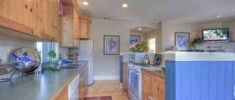 A kitchen with wooden cabinets, a stove, a microwave, and a sink.