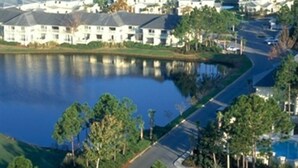 Un barrio residencial con casas, una masa de agua y una carretera.