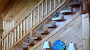 Een houten trap met decoratieve details en wandlampen.