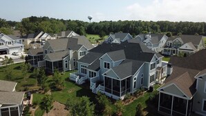 A residential area with modern houses, a water tower, and a well-maintained lawn. - SUPER 5 BR, 3.5 bath, sleeps 12, heart of Bayside! EV charger (Selbyville)