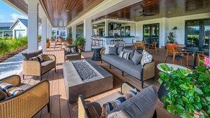 An outdoor patio area with seating, a fire pit, and a bar area. - SUPER 5 BR, 3.5 bath, sleeps 12, heart of Bayside! EV charger (Selbyville)