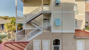 A multi-story building with a central staircase, balconies, and a flat roof. - Condo pool garage short walk to beach (Myrtle Beach)