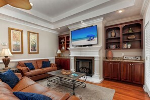 Ein Wohnzimmer mit Kamin, Fernseher und einer Couch.