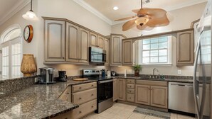 A kitchen with granite countertops, stainless steel appliances, and wooden cabinets. - Condo pool garage short walk to beach (Myrtle Beach)