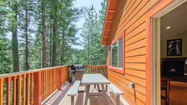 A wooden deck with a picnic table and grill, surrounded by tall trees. - Sequoias East (Yosemite National Park)