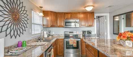 Enjoy cooking in this well-equipped kitchen with a large island, microwave and oven, and ample countertop space.