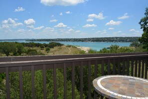 Ein Balkon mit Blick auf eine Küstenlandschaft, einschließlich eines Gewässers und weiter Landpartie.