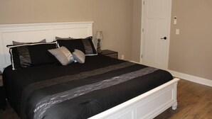 Una camera da letto con un letto grande, una testiera bianca e una porta.