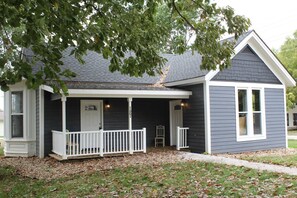 A small, single-story house with a porch, a front door, and a mailbox. - Drew's Den in Historic Downtown Pleasant Hill, MO (Pleasant Hill)