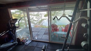 A home gym with exercise equipment, a treadmill, and a stationary bike. - Architect Designed And Decorated Waterfront House, You Have The Whole House! (Sooke)