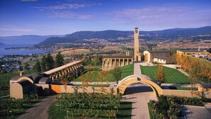 A campus with a prominent clock tower, green lawns, and a view of the surrounding landscape.
