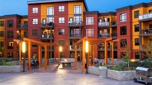 A multi-story hotel with a courtyard, outdoor seating, and a barbecue grill.