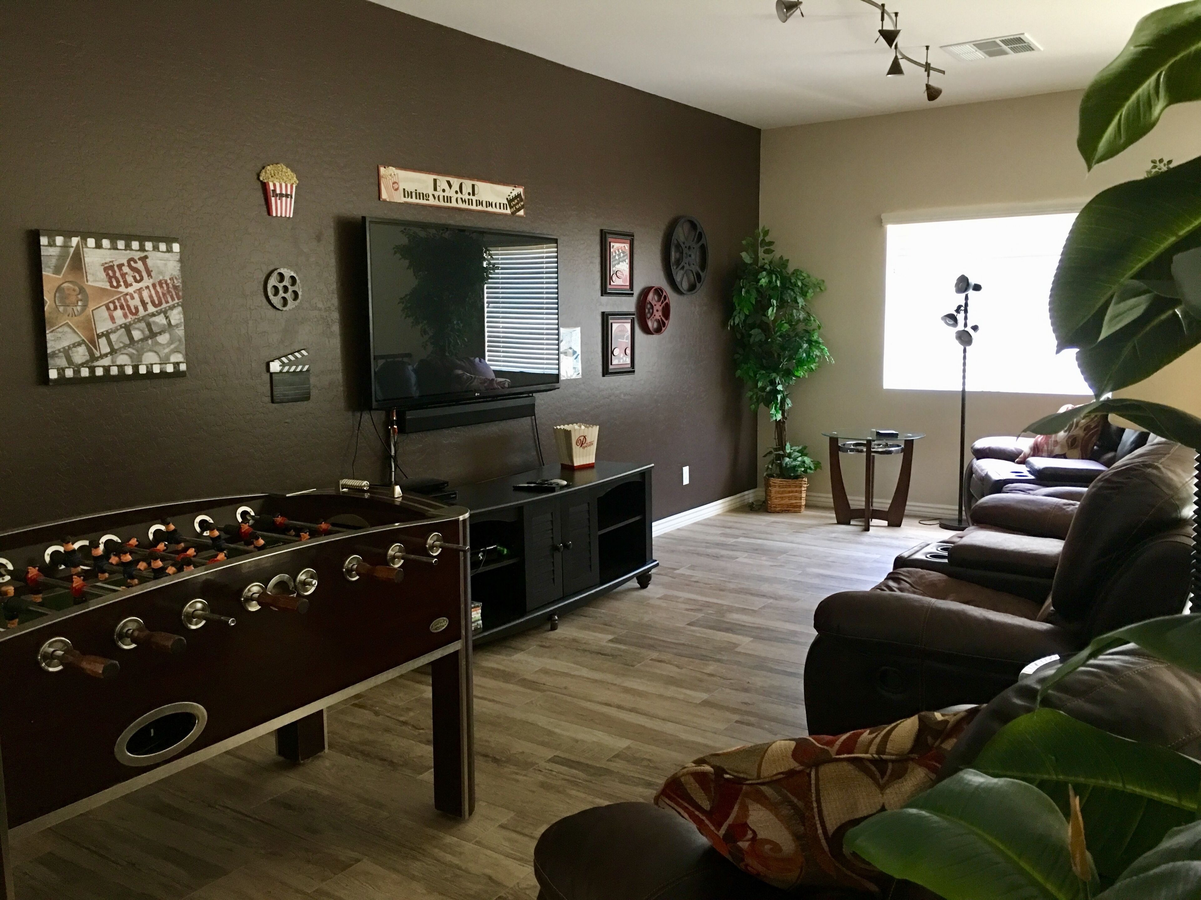 A living room with a foosball table, a flat-screen TV, and a sofa.