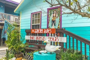 A turquoise building with a sign reading "The Dancing Dunes" and "Port Aransas Texas".
