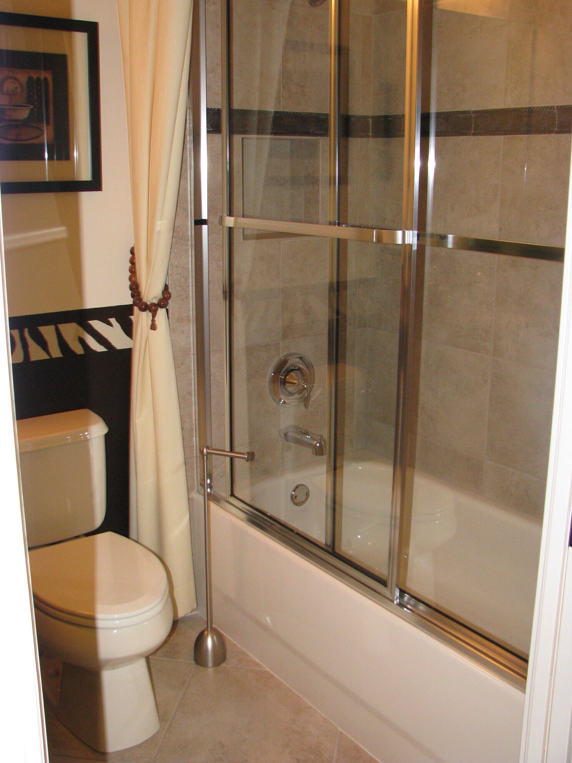 Un baño con ducha de vidrio, inodoro y bañera.
