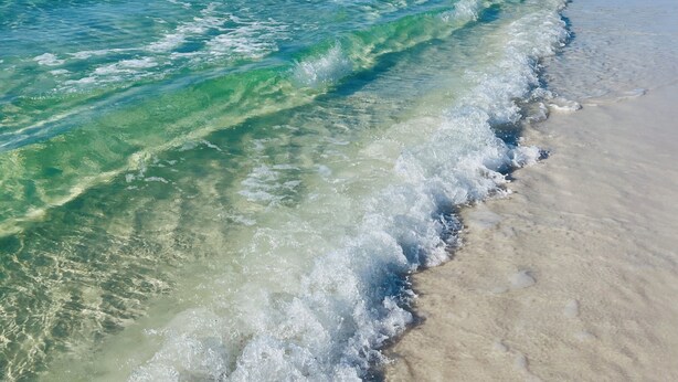 Ein Strand mit klarem türkisblauem Wasser und einem Sandstrand.