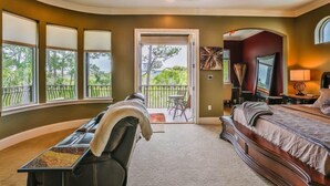 A bedroom with a large bed, a bench with a tray of snacks, a desk, and a view of the outdoors. - Casa Bahari W/Private Pool 5-Bed/Pool/Spa/Lux Amenities (Destin)