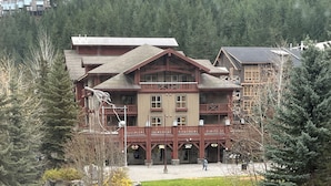 Eine Lodge mit Innenhof, Steintreppe zum Eingang und umgebendem Wald.