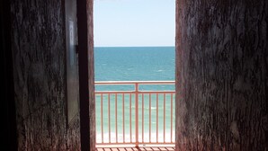 A corridor leading to a balcony with a view of the sea. - Right on the Gulf! Beautiful white sandy beachfront! Safe, quiet, and friendly! (Treasure Island)