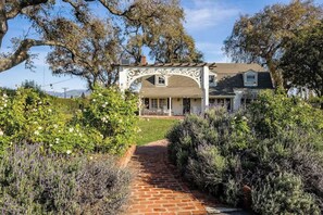 Une maison avec un chemin de briques menant à une arche blanche.