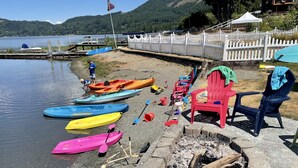 A lakeside setting with kayaks, paddleboards, and a fire pit. - Lakefront Paradise: Private Beach, Water Sports, Stunning Sunsets, Sleeps 8 (Bellingham)