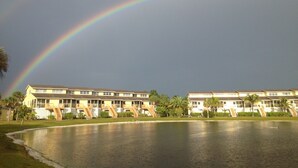 Ein Hotel mit Pool und einem Regenbogen am Himmel.