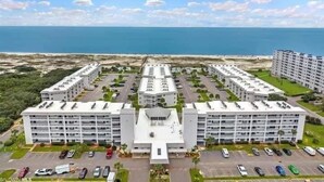 A modern hotel with multiple floors, a central courtyard, and a parking lot.