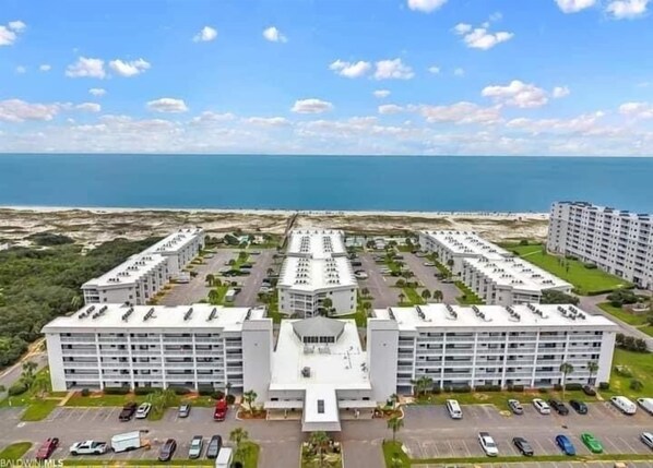 A modern hotel with multiple floors, a central courtyard, and a parking lot.