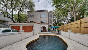 A two-story house with a swimming pool in the backyard.