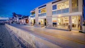 A beachfront hotel with multiple floors, large windows, and a balcony. - 2 Levels of Ocean Front + AC + Heart of MB (San Diego)