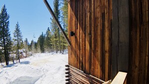 Una cabaña de madera con una escalera de piedra que lleva a una terraza de madera.
