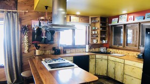 Una cocina con una isla central, armarios de madera y piso a cuadros.