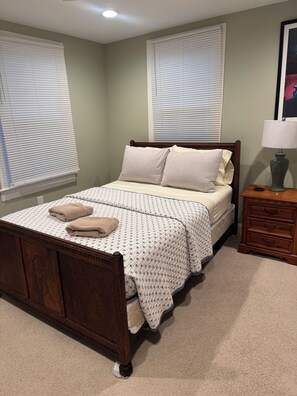 Un dormitorio con una cama, dos mesitas de noche y un tocador.
