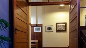 A wooden staircase leading to a room with a bed and a framed picture on the wall.