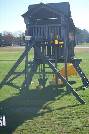 Explore the fun of a multi-level play structure with a slide and climbing elements in a park setting.