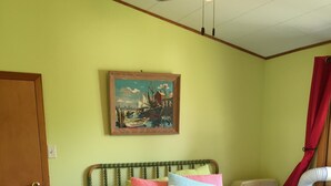 A bedroom with a bed, a painting, an air conditioner, and a door. - Family And Pet-Friendly On Waubeesee Lake ~ Includes Kayaks! (Wind Lake)
