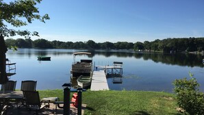 A lakeside dock with a boat, a wooden pier, and outdoor seating. - Family And Pet-Friendly On Waubeesee Lake ~ Includes Kayaks! (Wind Lake)