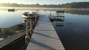 A wooden pier extending into calm water with boats docked at the end. - Family And Pet-Friendly On Waubeesee Lake ~ Includes Kayaks! (Wind Lake)