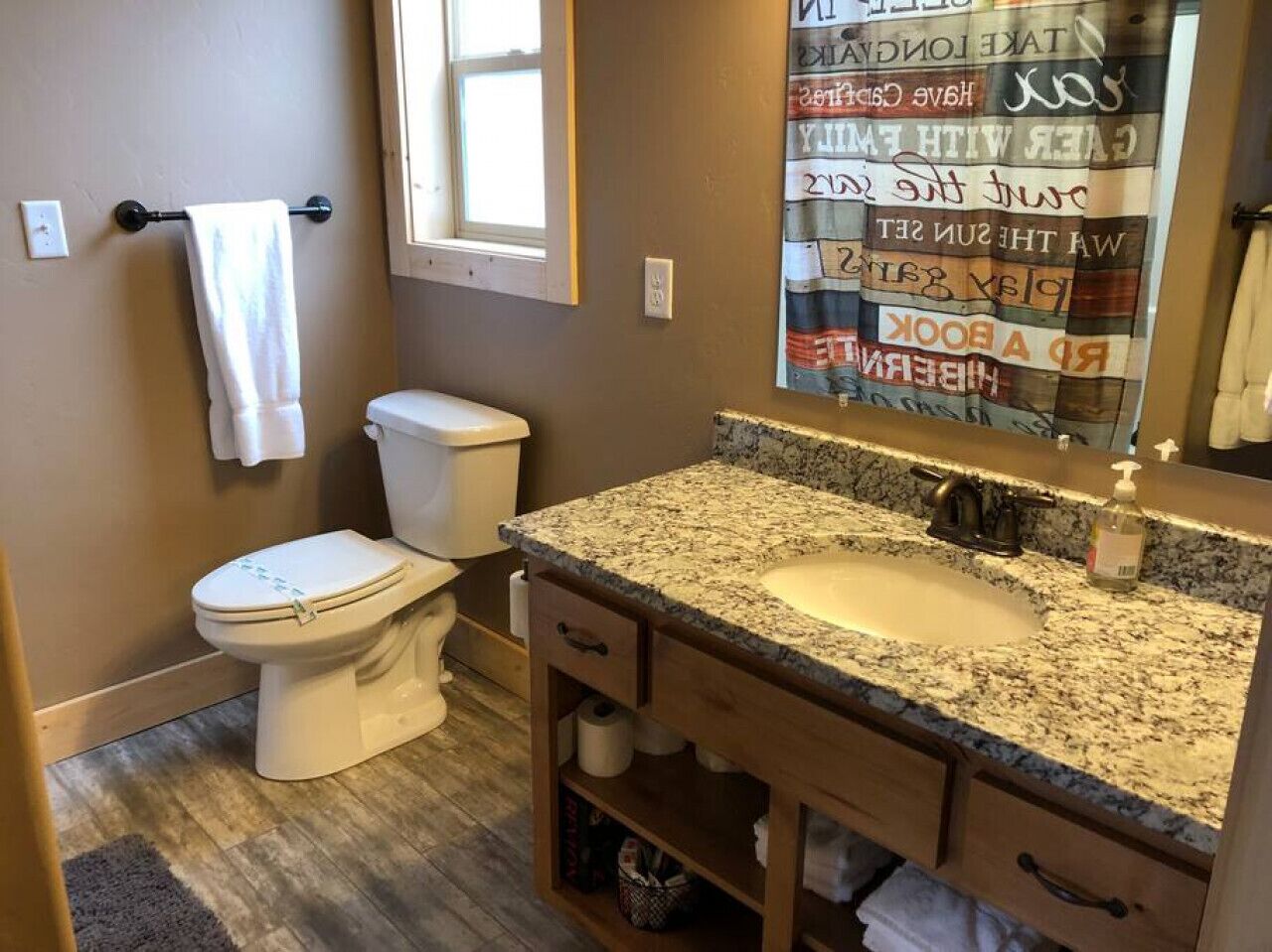 A bathroom with a toilet, sink, and vanity.