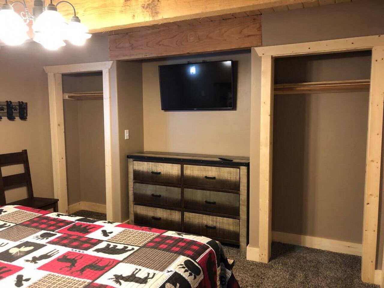 A bedroom with a bed, a dresser, a TV, and a closet.
