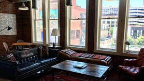 Un'accogliente area relax con divani in pelle, un tavolino da caffè e ampie finestre che offrono vista sulla città.