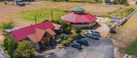 A vineyard with a tasting room and a building with a red roof.